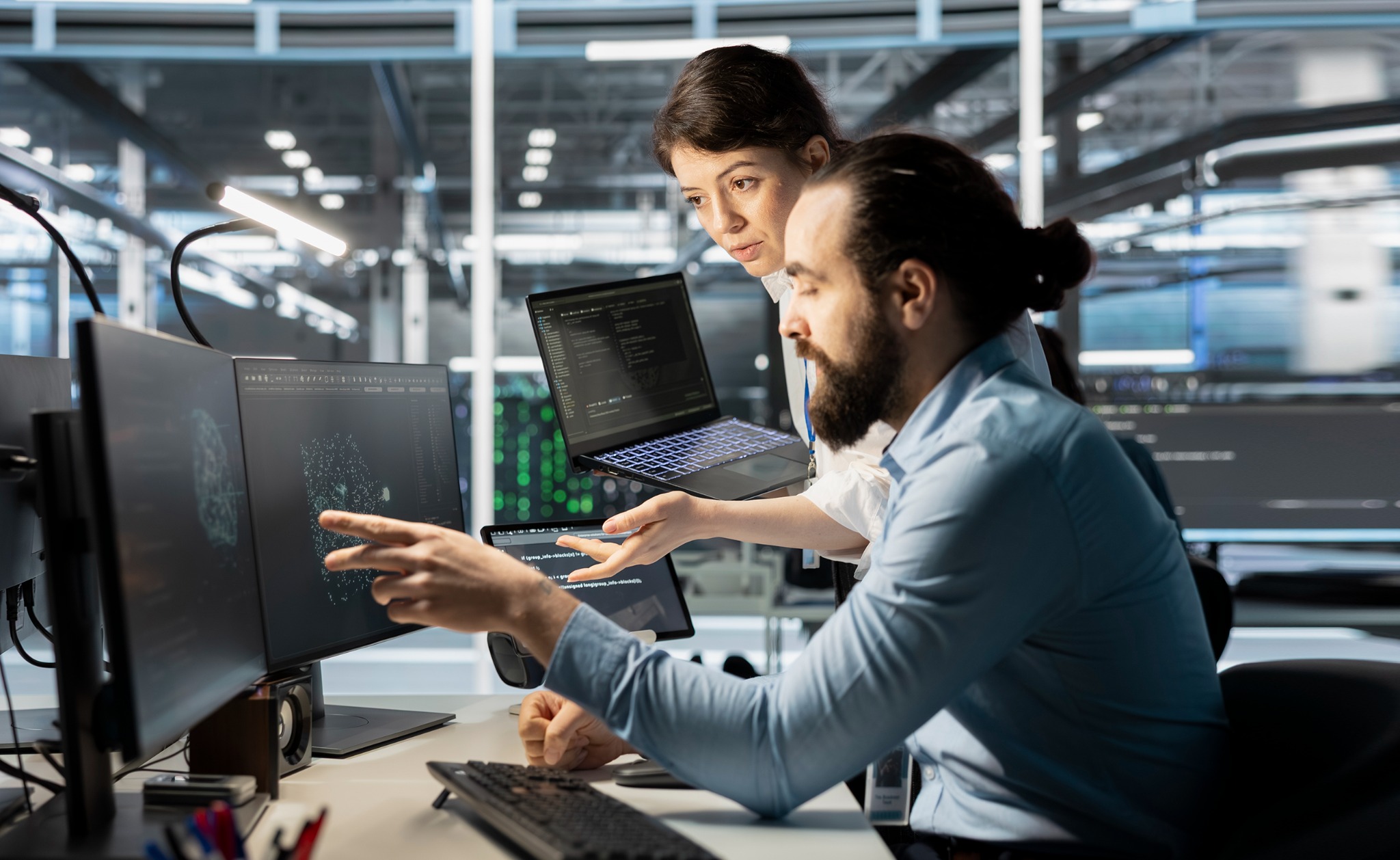 Technology team collaborating at computer workstations