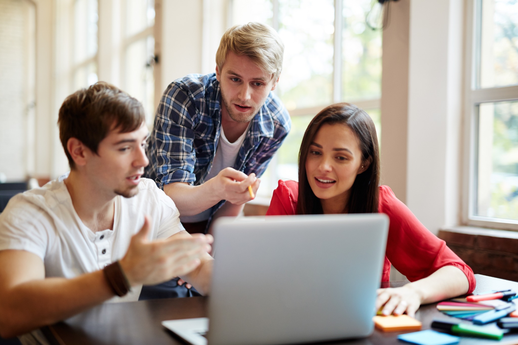 Consulting team collaborating around a laptop